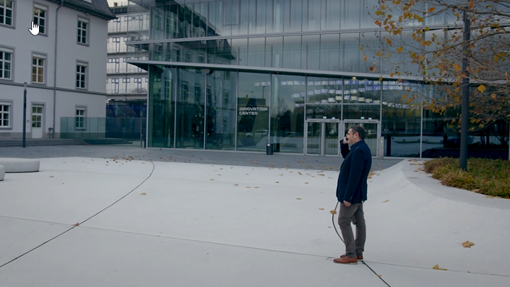 Person on phone standing outside of an office building.